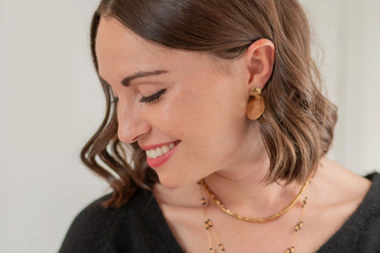 femme portant des bijoux dorés sur une peau claire