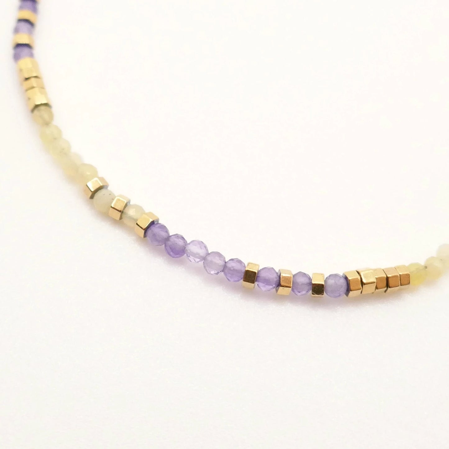 Petit bracelet en perles colorées jaunes et violettes monté sur base en or