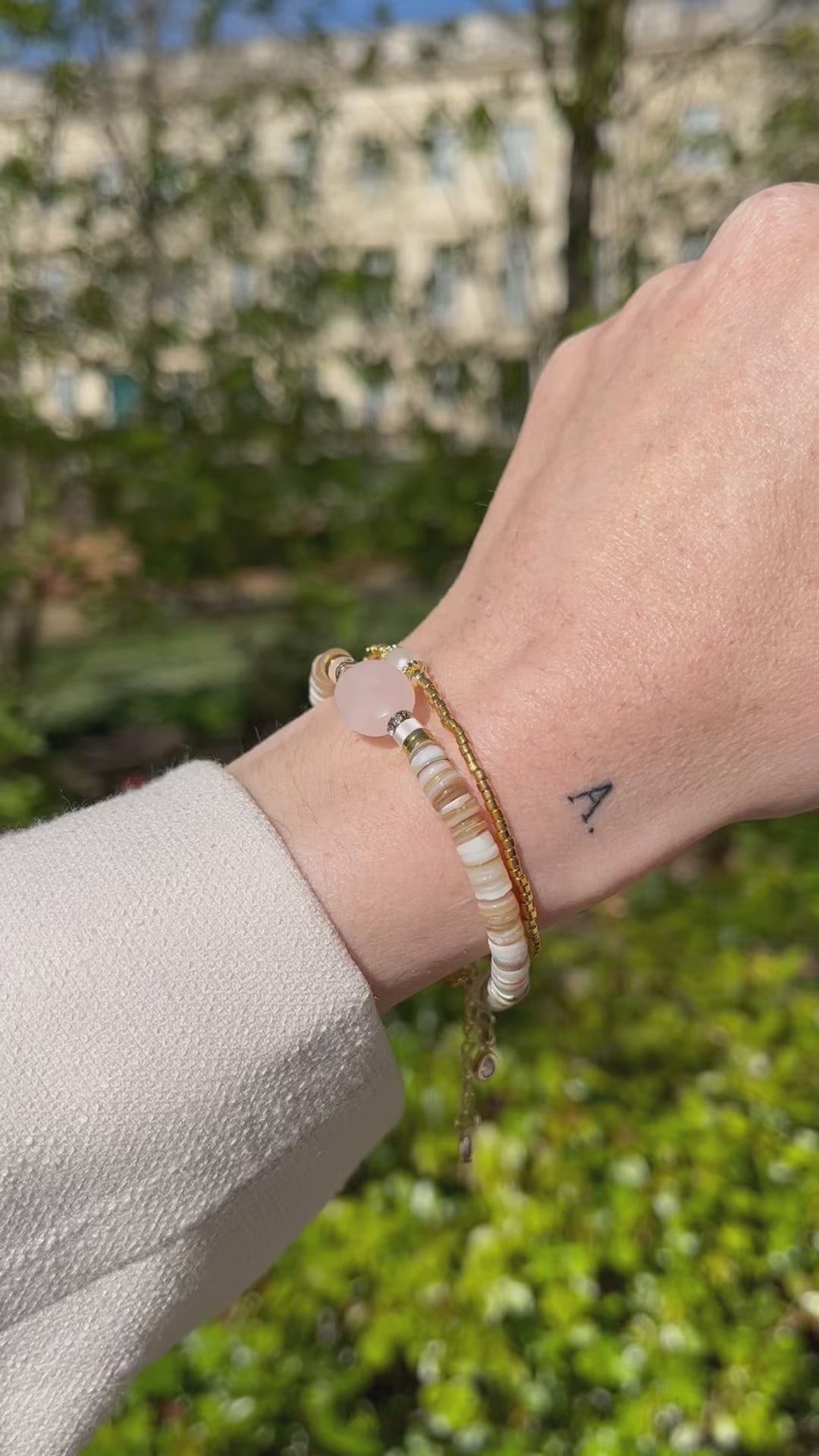 Femme portant deux jolis bracelets en perles beiges et dorées