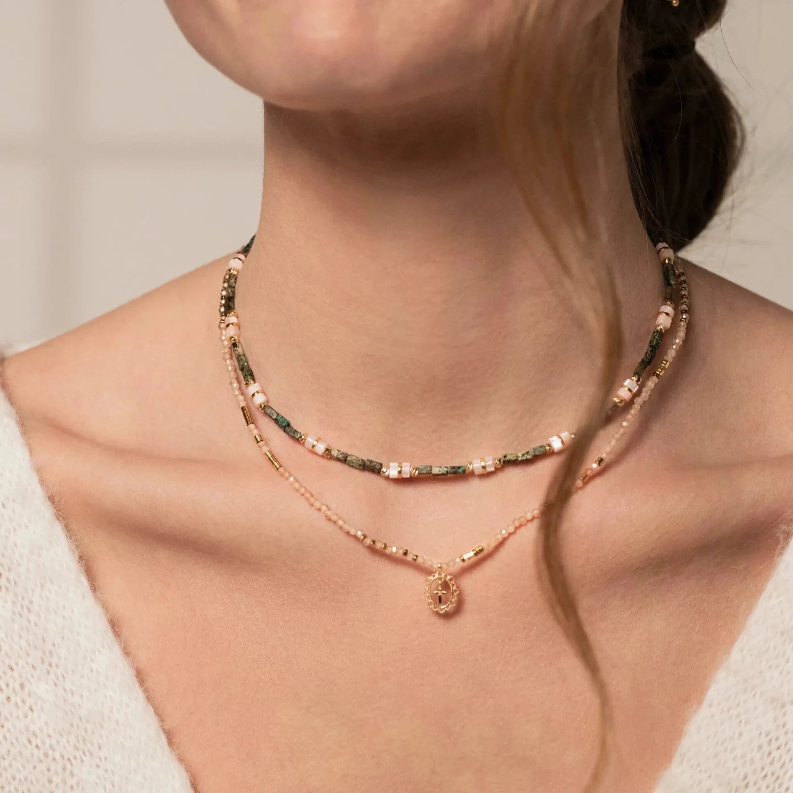 Femme portant une accumulation de colliers artisanaux fabriqués à la main