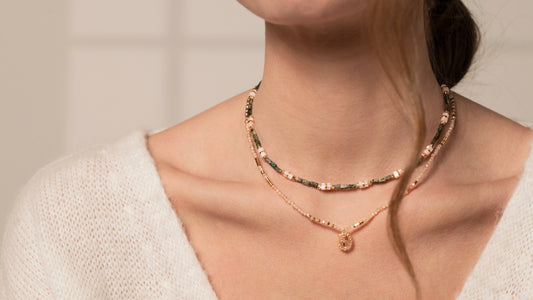 femme portant deux jolis colliers en perles et médaillon croix