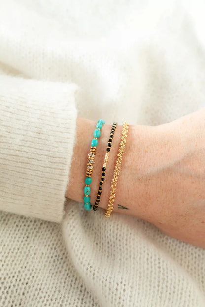 femme portant trois bracelets fins en perles