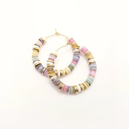 Boucles d'oreilles créoles colorées en perles heishi et rondelles or sur fond blanc