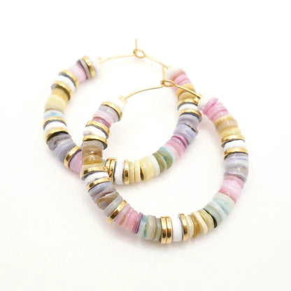 Boucles d'oreilles créoles colorées en perles heishi et rondelles or sur fond blanc