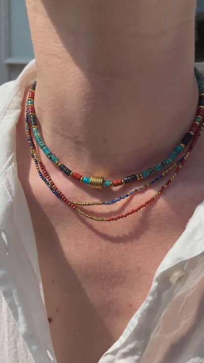 Femme portant une accumulation de colliers fins et colorés