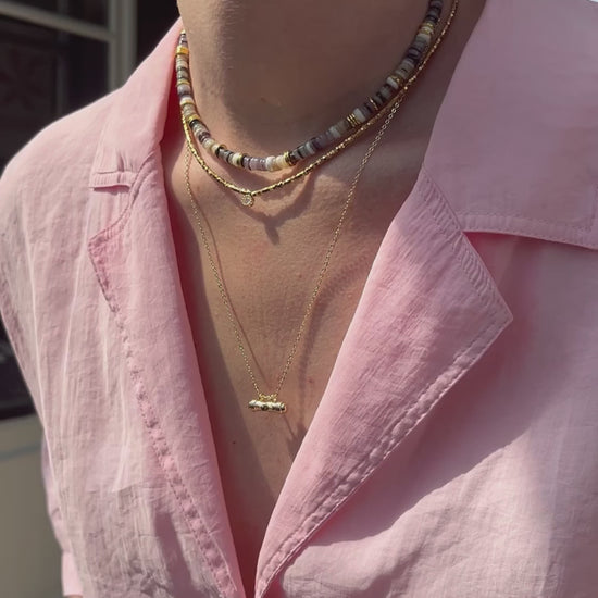 femme portant plusieurs colliers colorés en perles naturelles