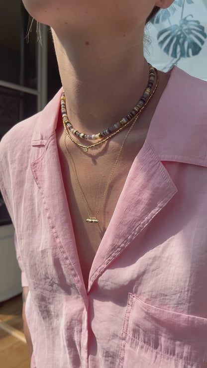 femme portant plusieurs colliers colorés en perles naturelles