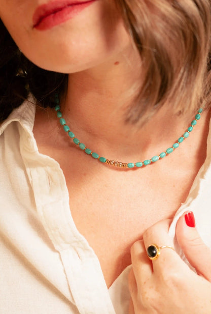 femme portant un collier ras de cou en perles bleues et or