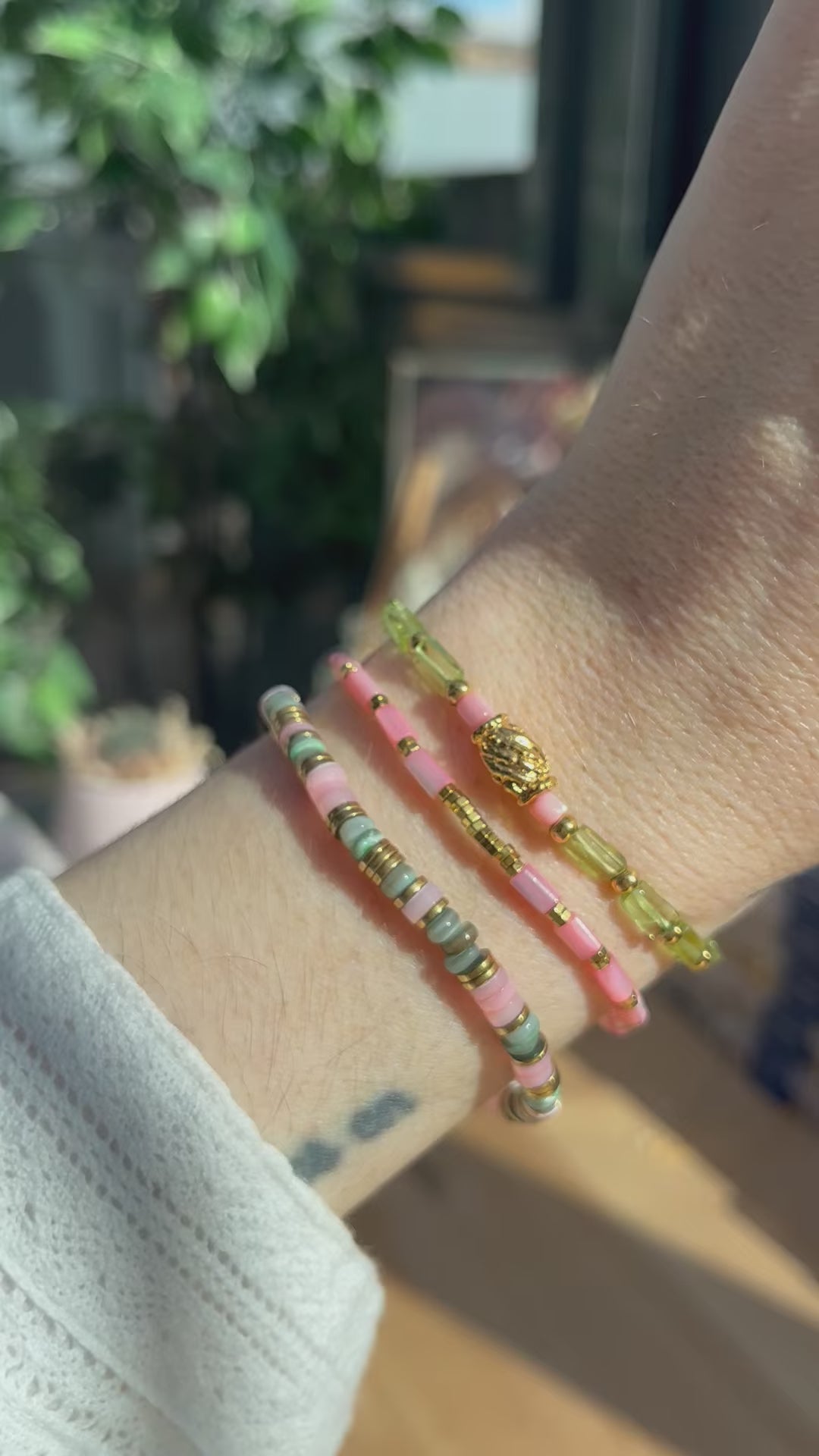 trois bracelets en accumulation roses et verts