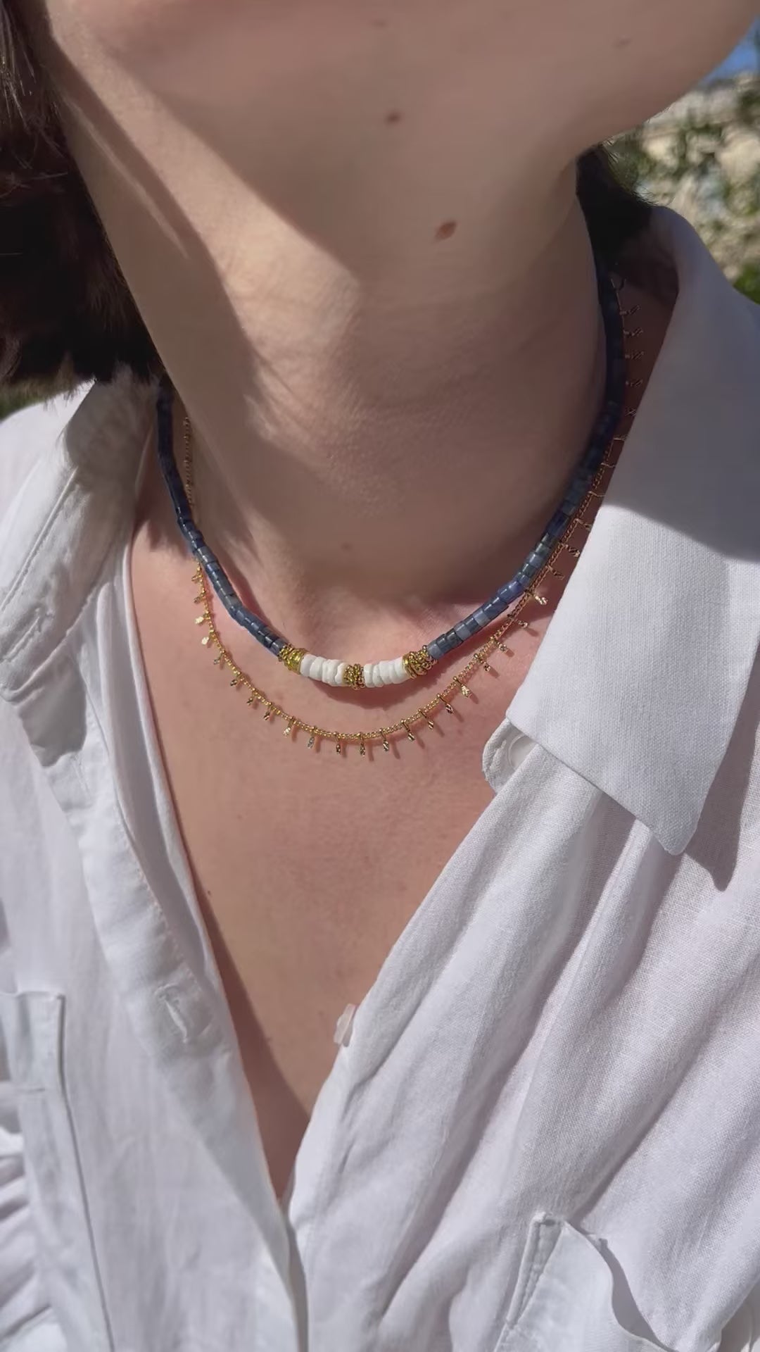 femme portant deux colliers en perles or et bleu
