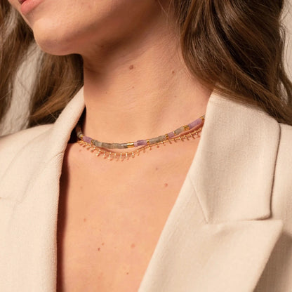 Femme portant une accumulation de colliers en perles et chaine dorée