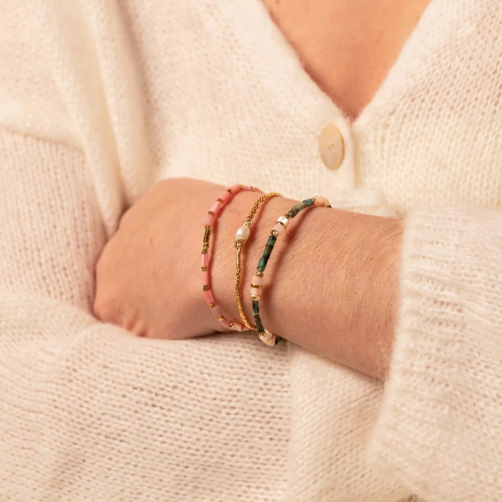 poignet de femme avec trois bracelets colorés et estivaux