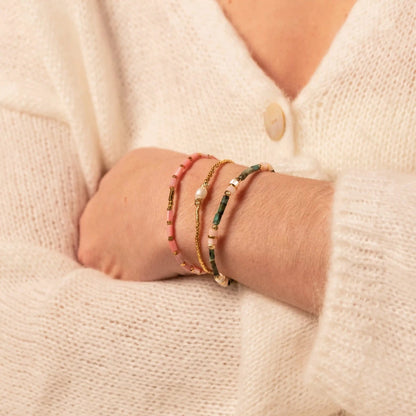 poignet de femme avec trois bracelets colorés et estivaux