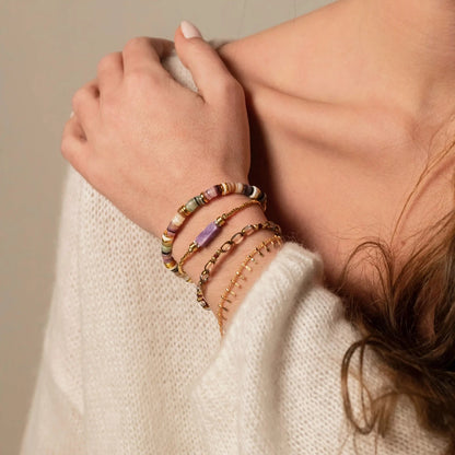 femme portant une accumulation de bracelets dont un bracelet chaine plaqué or orné de pampilles martelées