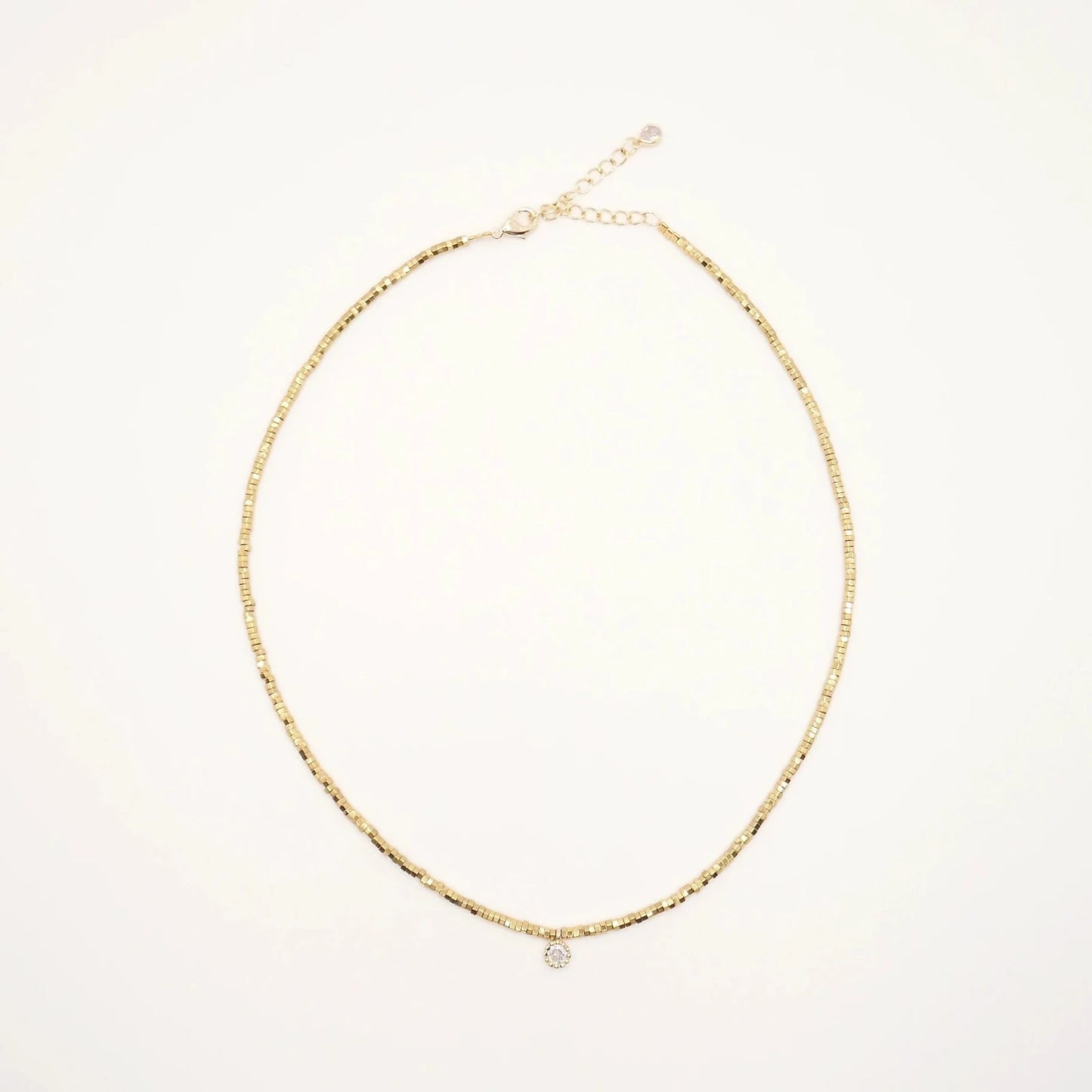collier en perles or dorées et petit médaillon aux crénelures dorées avec un strass zircon au centre