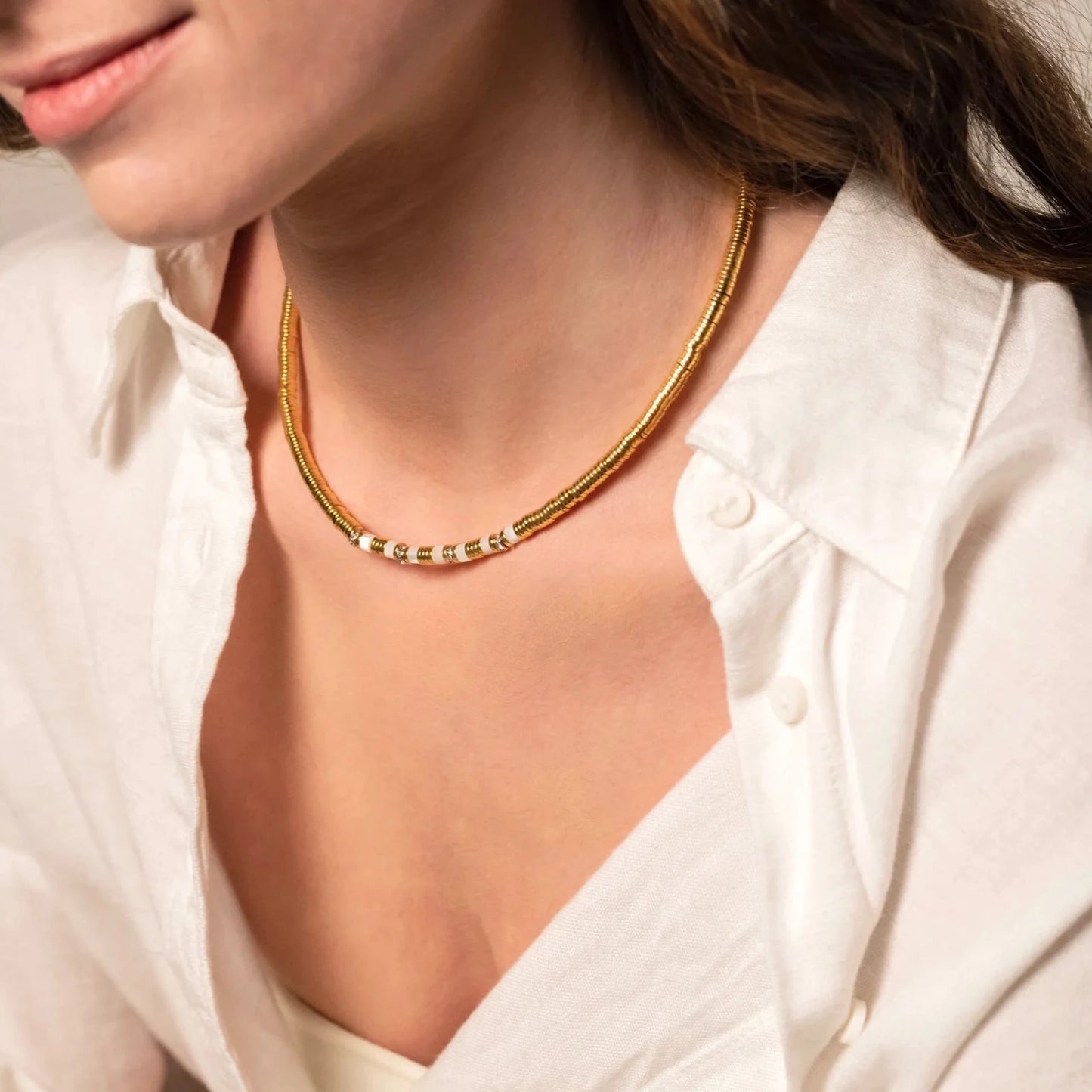 Femme portant un collier rond en or avec petits stass intégrés