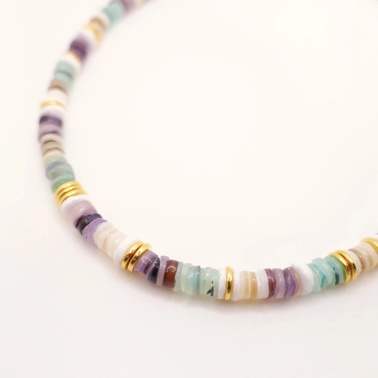 Collier en perles multicolores de coquillages et détails dorés
