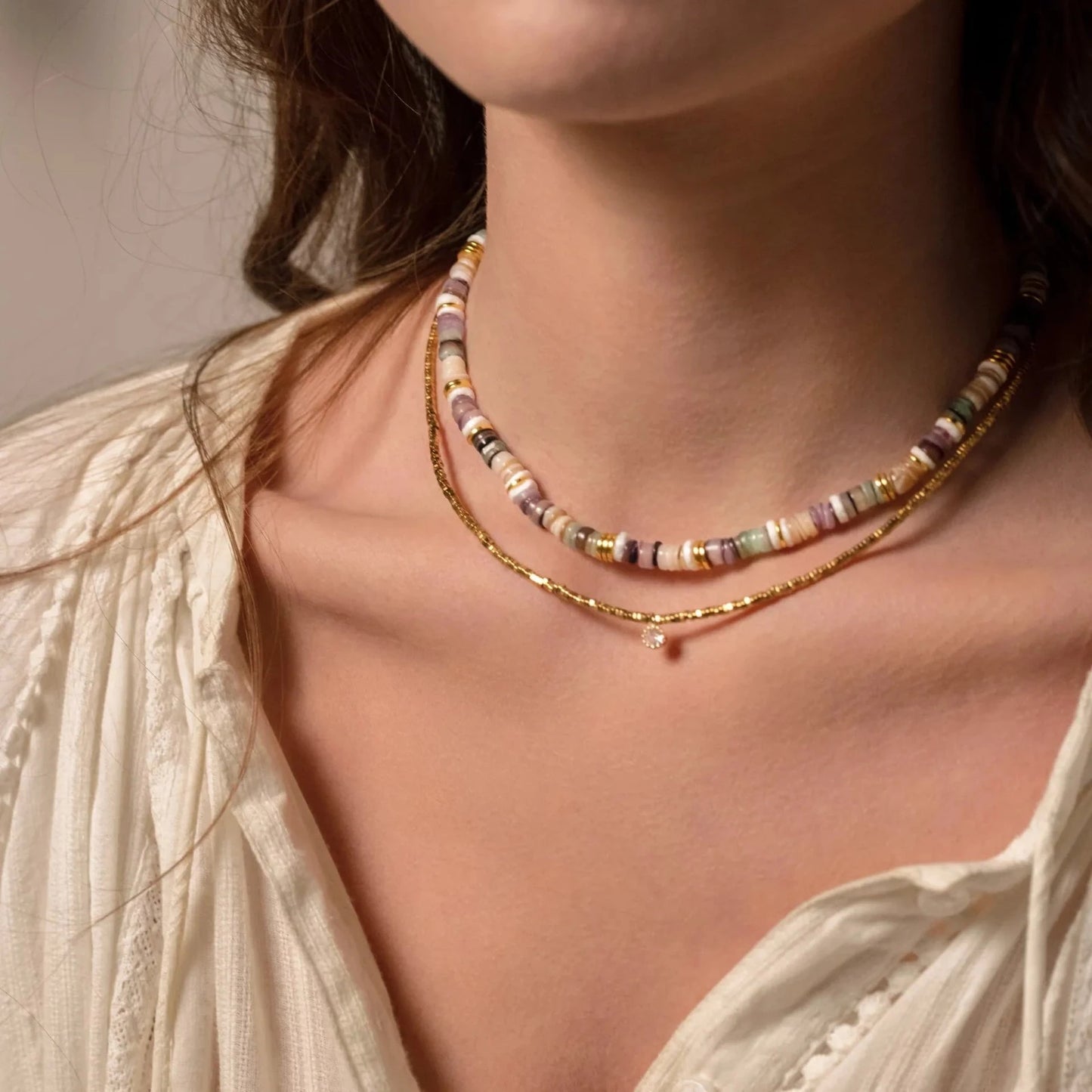 Femme portant deux colliers en perles et en or