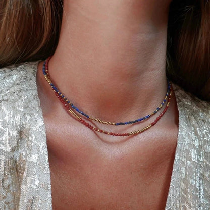 femme portant deux colliers de perles colorées et perles or avec veste argentée