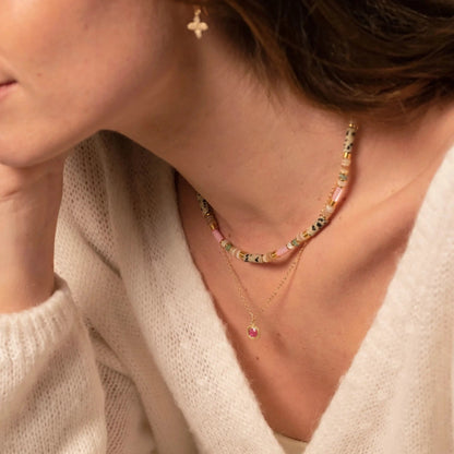 femme portant des colliers fins en perles et en or en accumulation