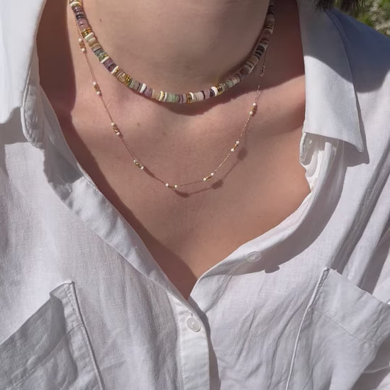 femme portant un collier en perles colorées et dorées